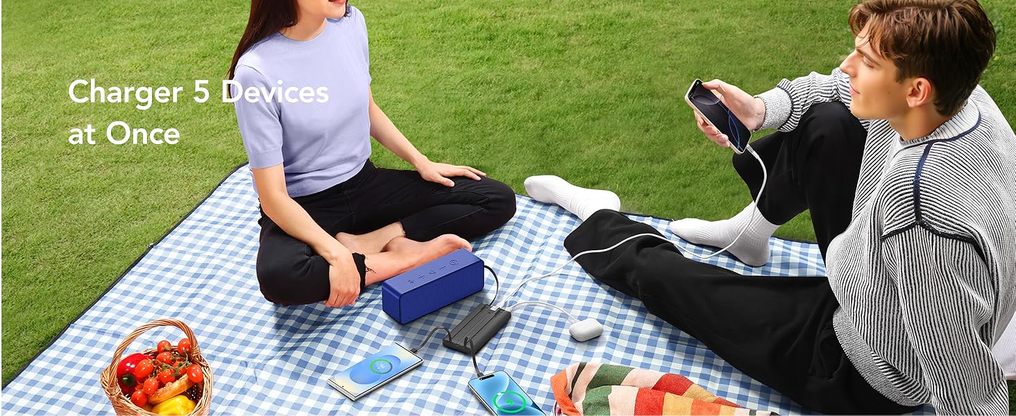 Outdoor picnic scene on checkered blanket showing portable device with text 'Charge 5 Devices at Once' visible.